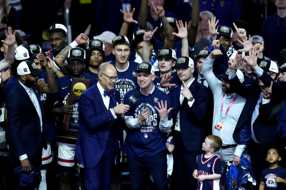 4 月 8 日，康涅狄格大学教练丹·赫尔利和他的队员们在击败普渡大学赢得全国冠军后庆祝。