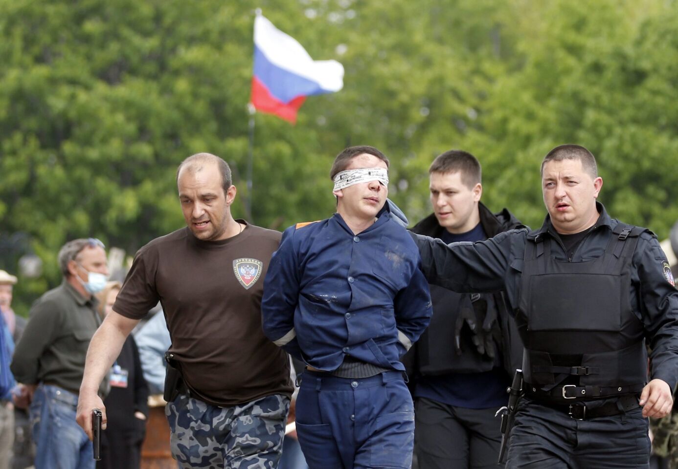 Pro-Russian supporters lead an unidentified man in front of the occupied regional administration building in Donetsk, Ukraine. Pro-Russian separatists said that up to 20 of their fighters may have been killed in clashes with government troops in the eastern Ukrainian city of Slaviansk.