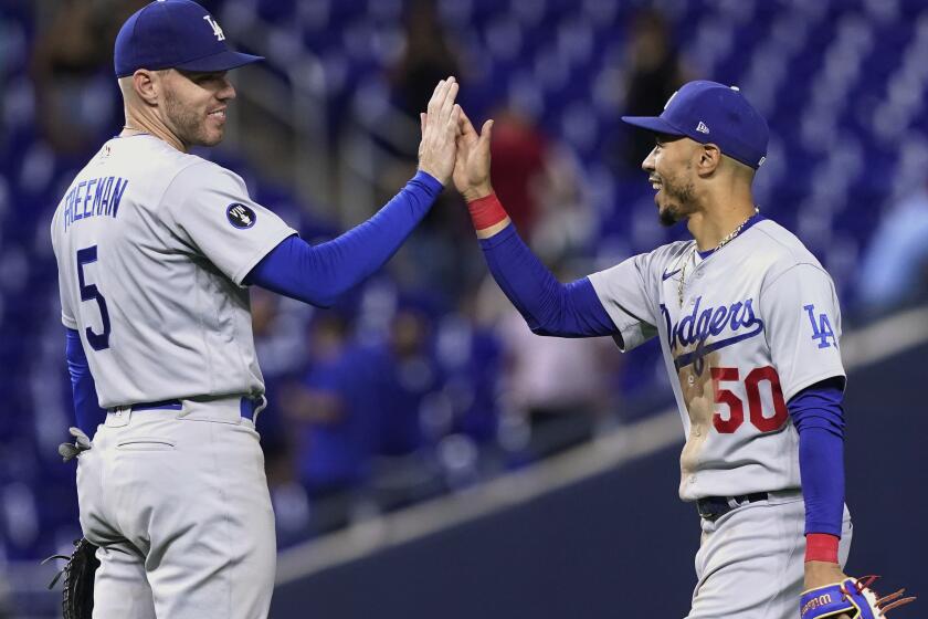 The Dodgers' Mookie Betts, right, and Freddie Freeman celebrate the team's extra-inning win at Miami on Aug. 26, 2022.