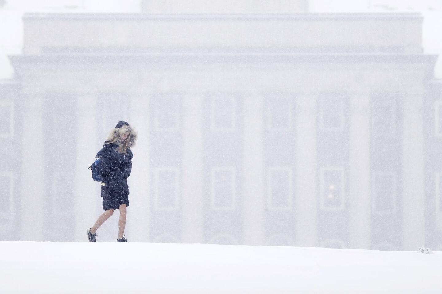 A woman walks on the Penn State University campus during a snowstorm Friday in State College, Pa. Forecasters say a storm will dump up to 6 inches of snow on the Northeast and mid-Atlantic on Friday.