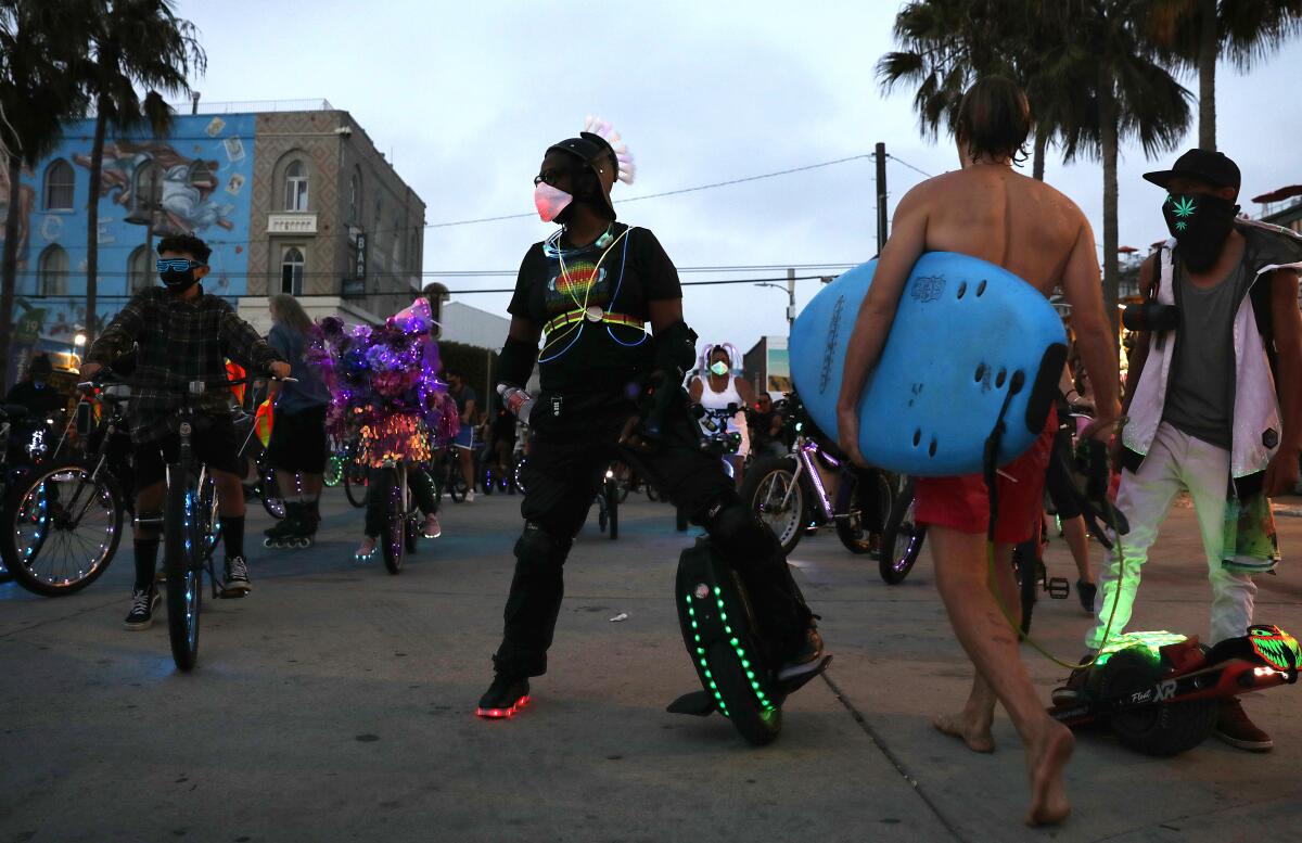 Lisa Mitchell of Los Angeles waits with her electric unicycle for the start of the Venice Electric Light Parade on Aug. 16.