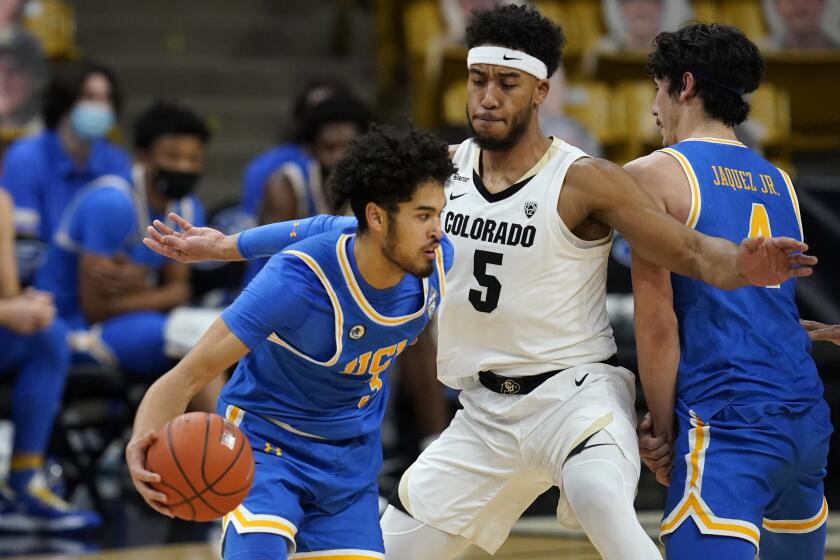 UCLA guard Johnny Juzang is defended by Colorado guard D'Shawn Schwartz during the second half of an NCAA college basketball game Saturday, Feb. 27, 2021, in Boulder, Colo. (AP Photo/David Zalubowski)
