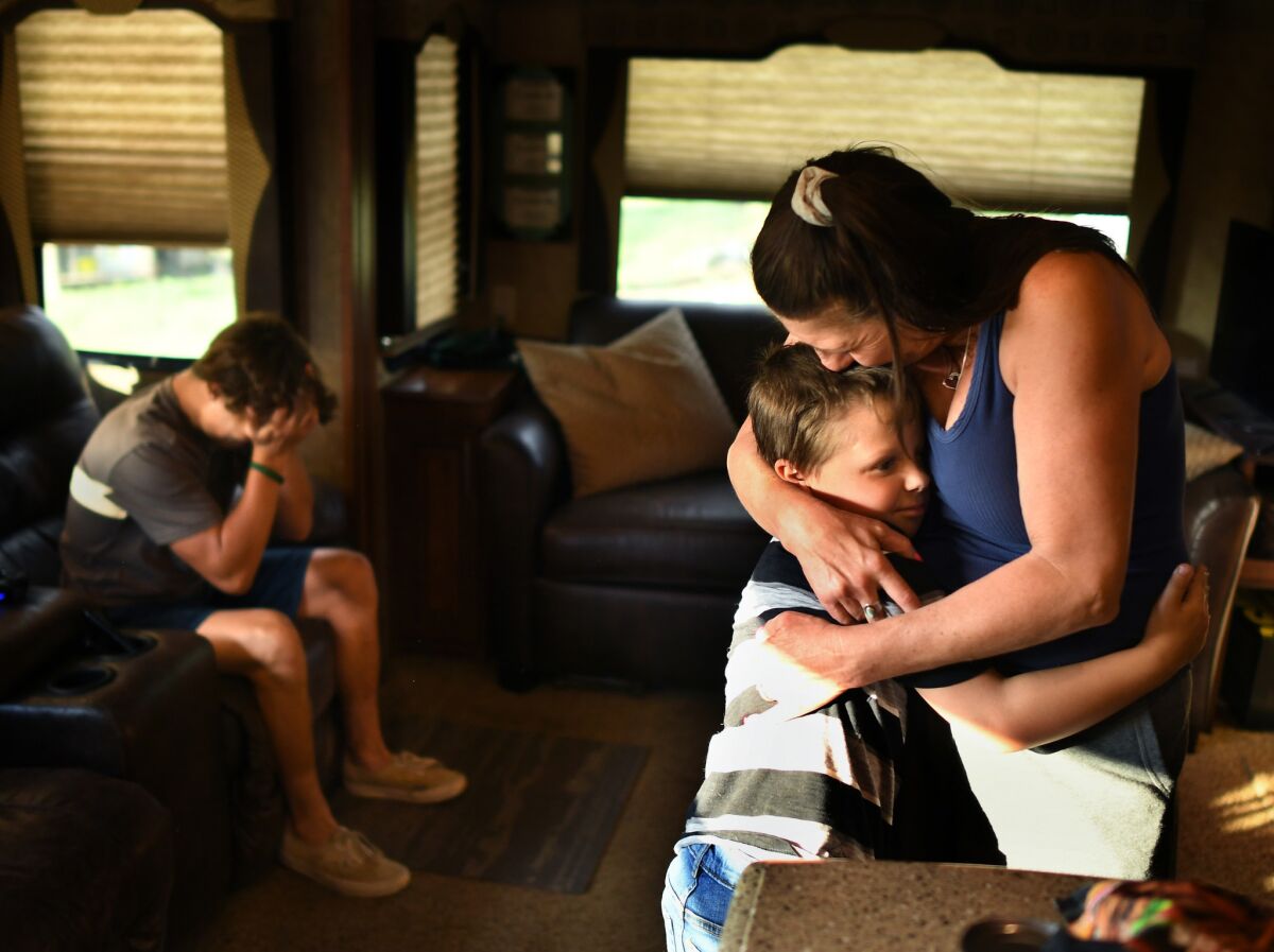 Stetson Morgan, Paradise High School football player, sits on the couch as his mother, Emmie, comforts her nephew Cody after talking about the fire that burned their home.