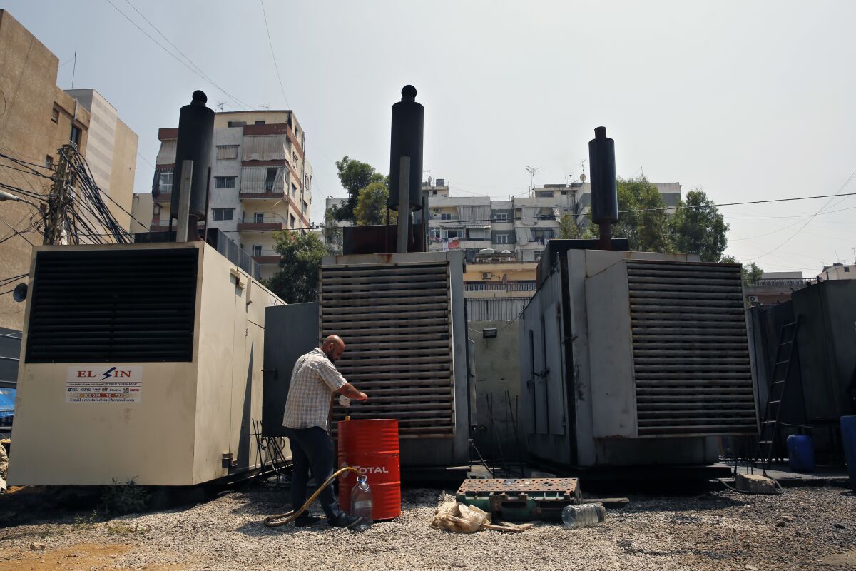 FILE - Mamdouh al-Amari refuels privately-owned diesel generators that provide power to homes and businesses, in the southern suburbs of Beirut, Lebanon, July 16, 2018. Internet services were disrupted in Lebanon Sunday, Jan. 16, 2022, because of diesel shortages, according to the state provider, adding another essential service to the list of casualties of the country’s snowballing economic crisis. (AP Photo/Bilal Hussein, File)
