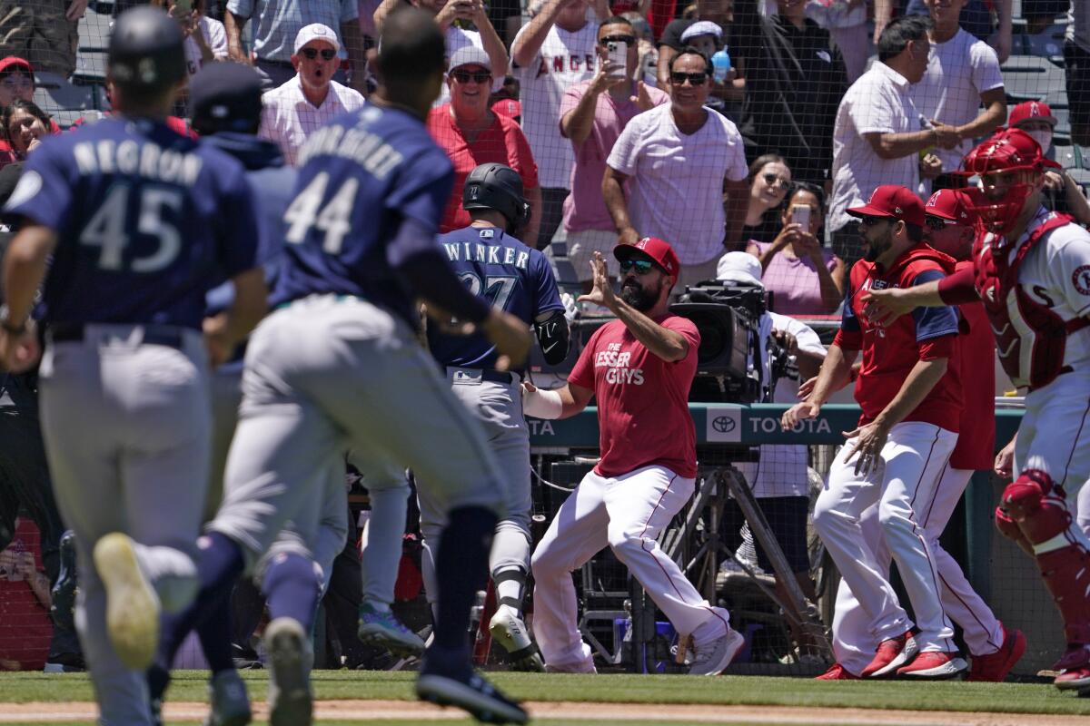 Seattle Mariners' Jesse Winker, center left, fights with Los Angeles Angels Anthony Rendon.