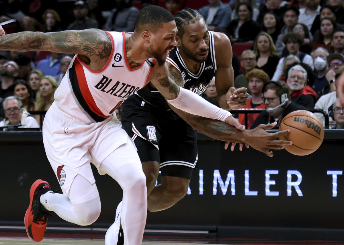 Clippers forward Kawhi Leonard, right, tries to steal the ball away from Portland Trail Blazers guard Damian Lillard.