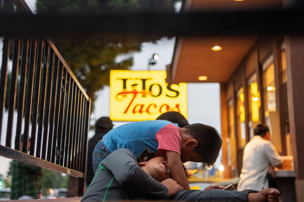 Kids mess around as customers line up outside Culver City staple Tito's Tacos.