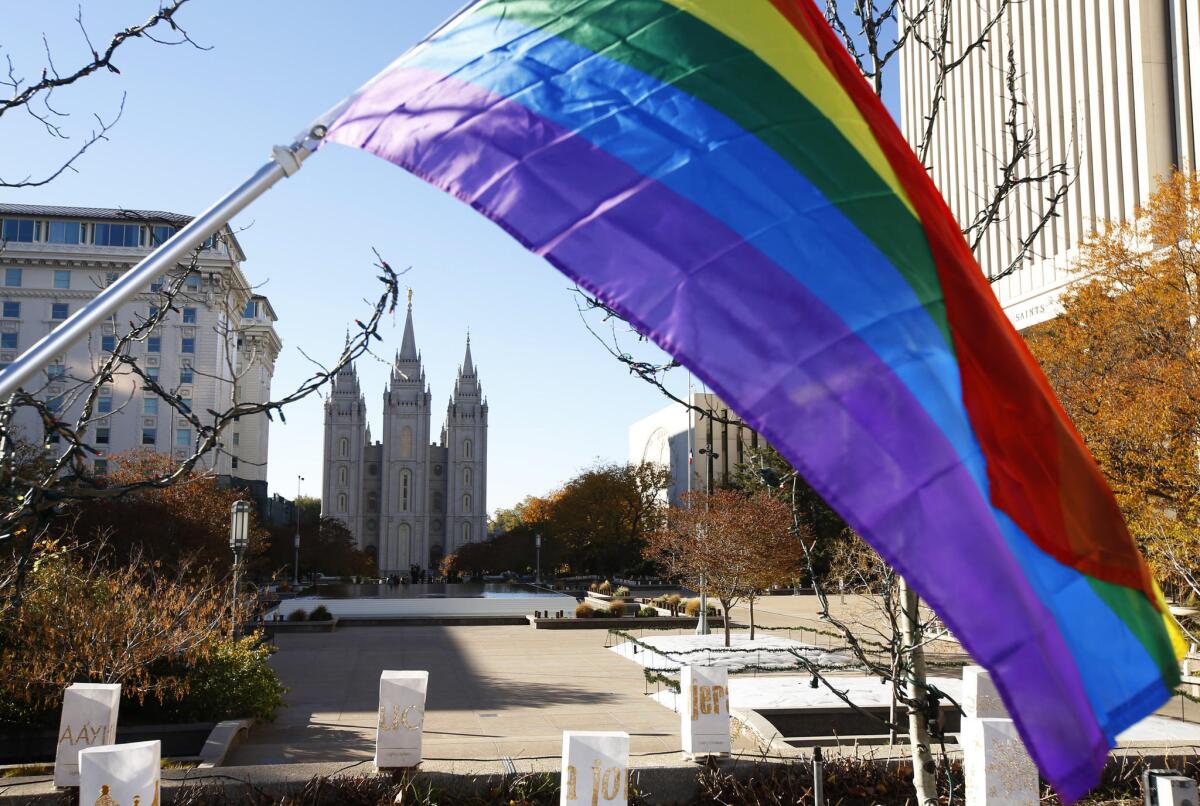 A pride flag flies in front of the Historic Mormon Temple on Nov. 14, 2015, as part of a protest where people resigned from the Church of Jesus Christ of Latter-Day Saints in response to a change in church policy toward married LGBT same sex couples and their children in Salt Lake City.