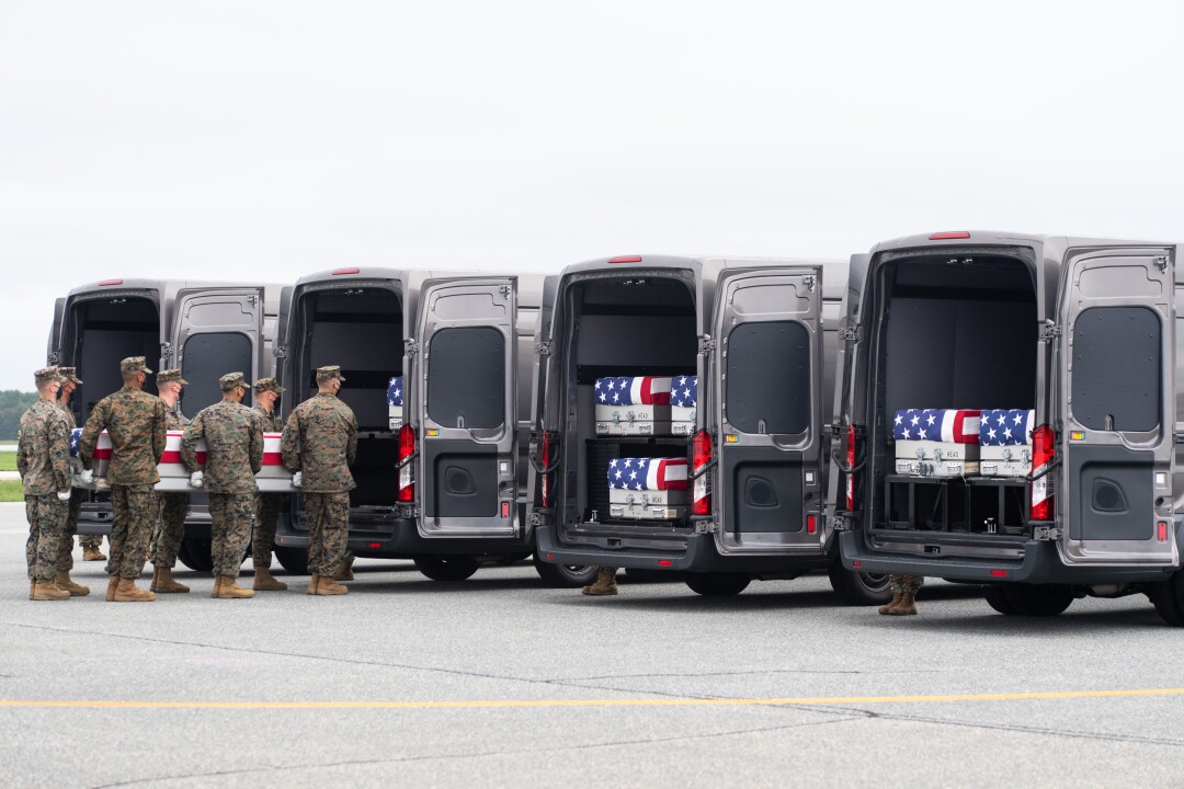 A case with the remains of a fallen service member is placed inside a transfer vehicle at Dover Air Force Base. 