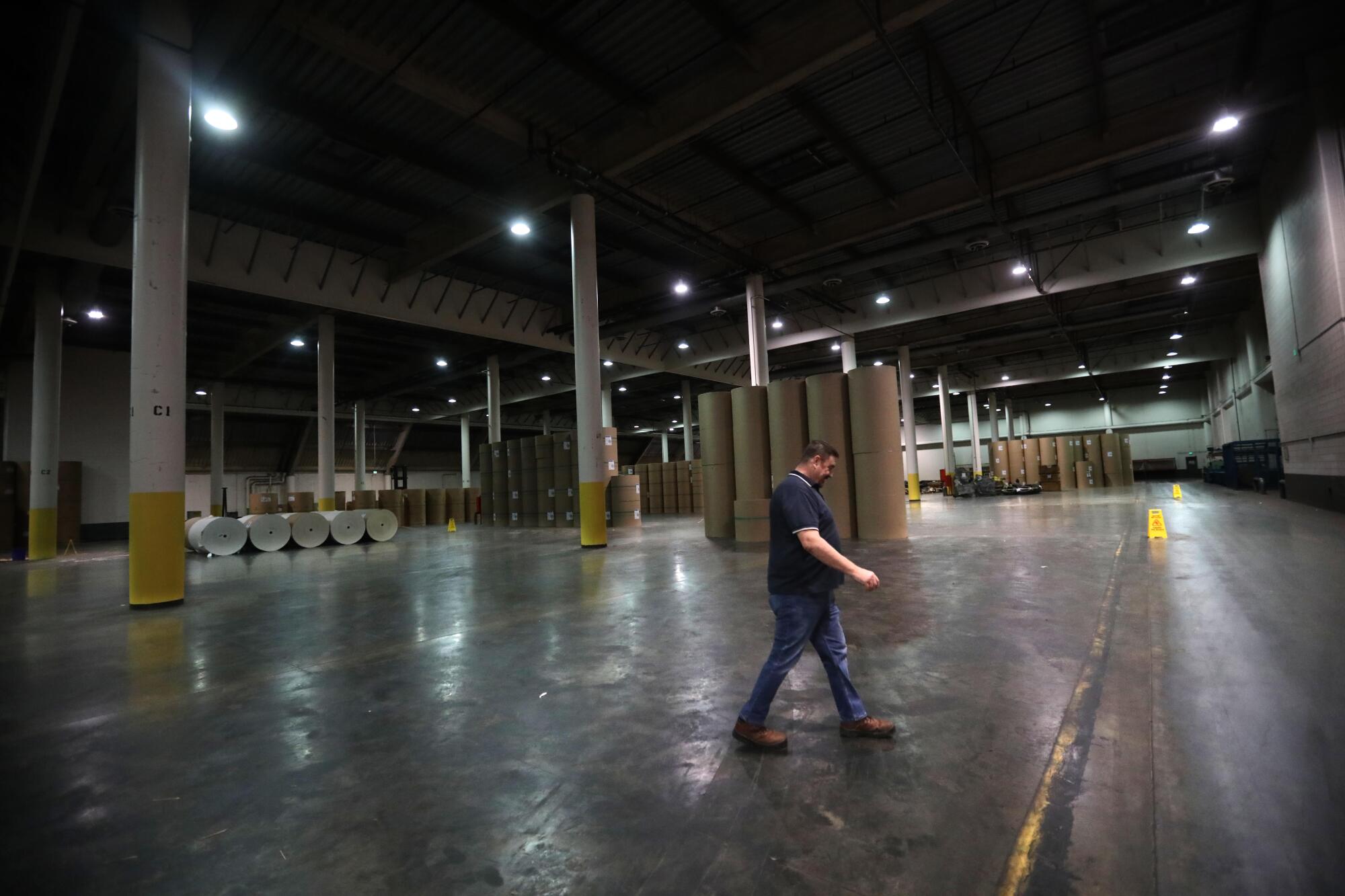 Pressroom supervisor Kal Hamalainen walks through the paper warehouse.
