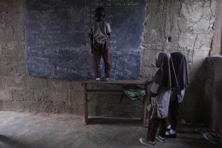 Students of Excellent Moral School attempt to answer a mathematics question on a blackboard inside a dimly lit classroom in Ibadan, Nigeria, Tuesday, May 28, 2024. The lack of reliable electricity severely affects education and businesses in Nigeria. (AP Photo/Sunday Alamba)