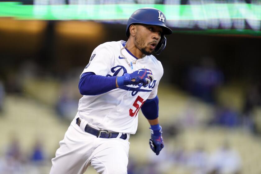 Los Angeles Dodgers' Mookie Betts rounds first base after a ground ball and fielding error.