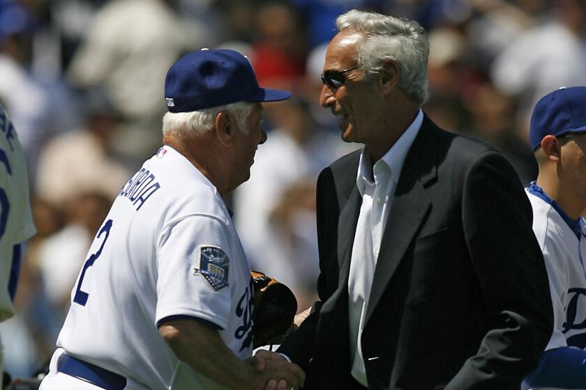 Former Dodgers manager Tom Lasorda, left, shakes hands with Sandy Koufax before the team's 2008 season opener.