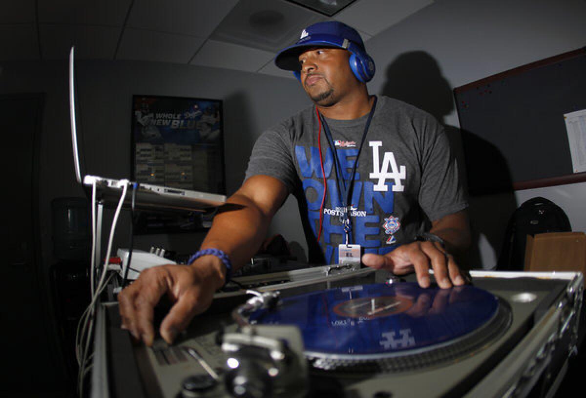 DJ Severe (Lanier Stewart) mixes music while fans arrive at Dodger Stadium as the Los Angeles Dodgers play the St. Louis Cardinals in Game 3 of the NLCS.