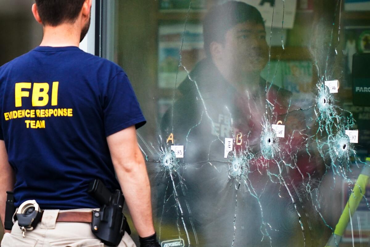 Una multitud se congrega cuando la policía investiga un tiroteo en un supermercado