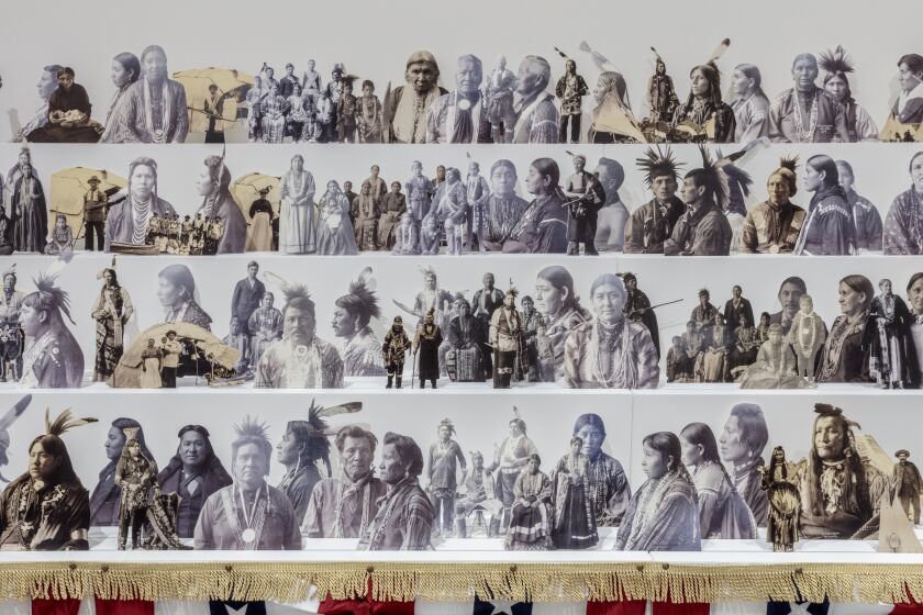 A detail of an installation by Wendy Red Star shows cut outs of vintage images of Indigenous leaders propped on risers
