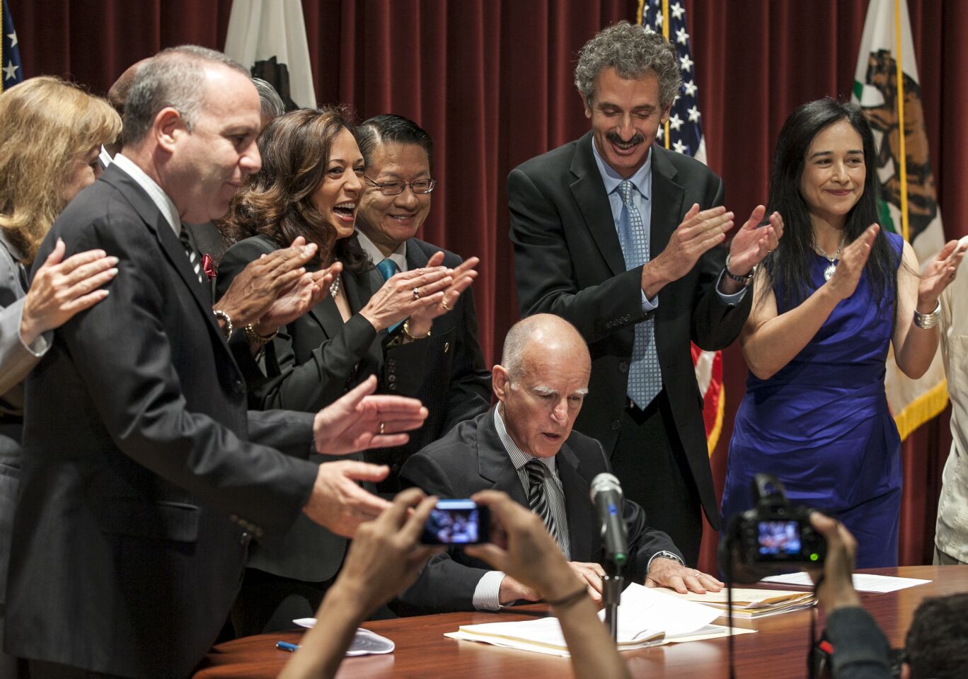 July 11, 2012: Calif. Gov. Jerry Brown is applauded by state Atty. Gen. Kamala Harris and other officials.
