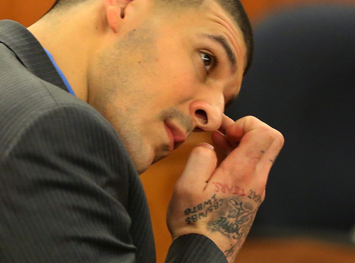 Former New England Patriots tight end Aaron Hernandez wipes his face as he listens to the judge speak to the jury during his murder trial Tuesday at Bristol County Superior Court in Fall River, Mass.