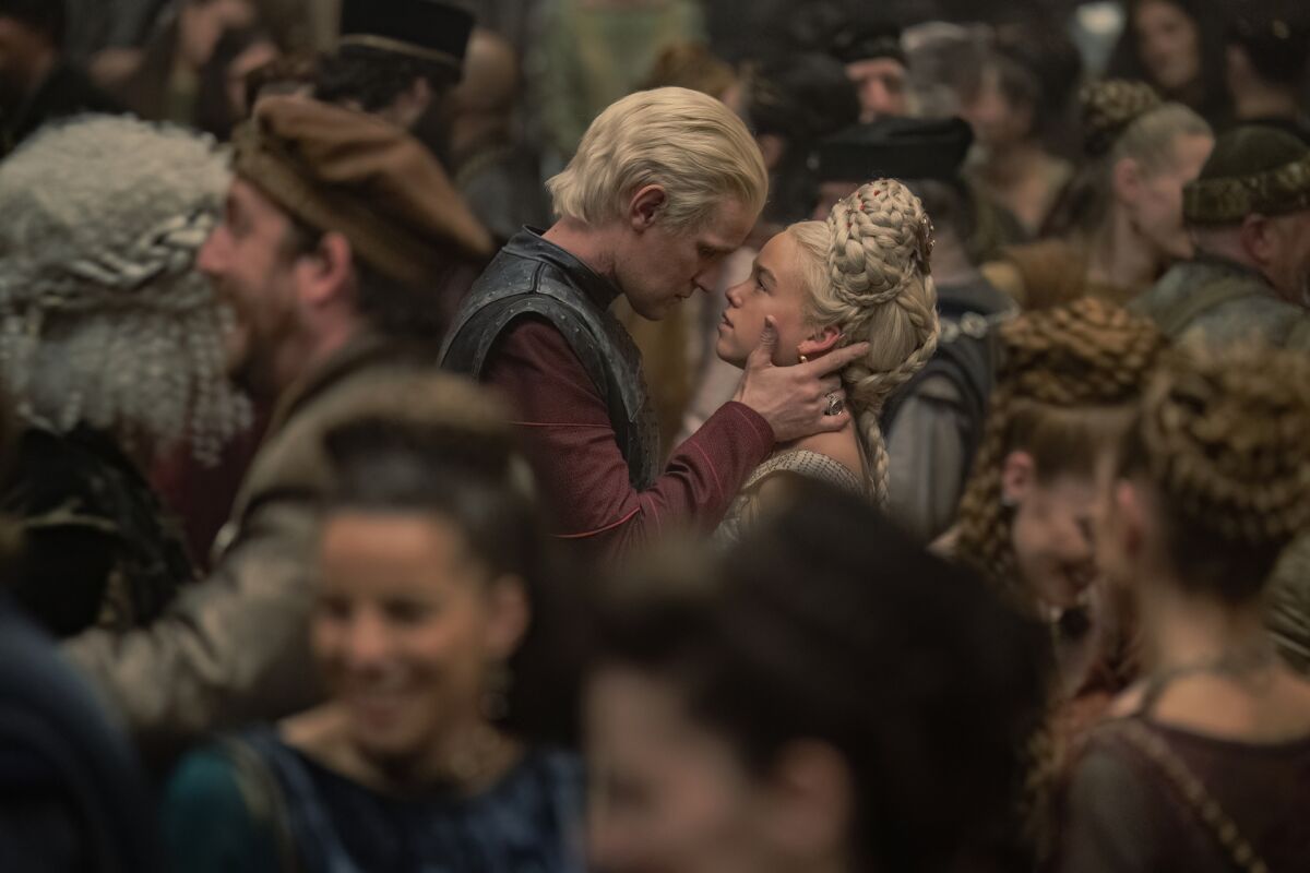 a man and a young woman close enough to kiss amid a crowd of revelers 