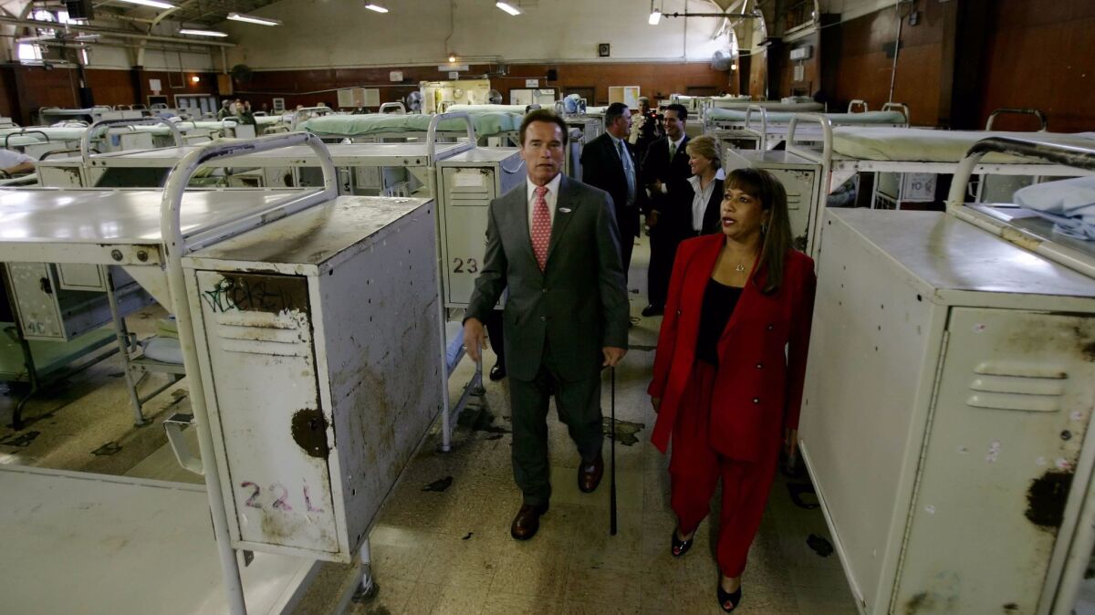Then-Gov. Arnold Schwarzenegger, left and California Rehabilitation Center Warden Guillermina Hall, right, tour a prison gym in March 2007 in Norco, Calif.