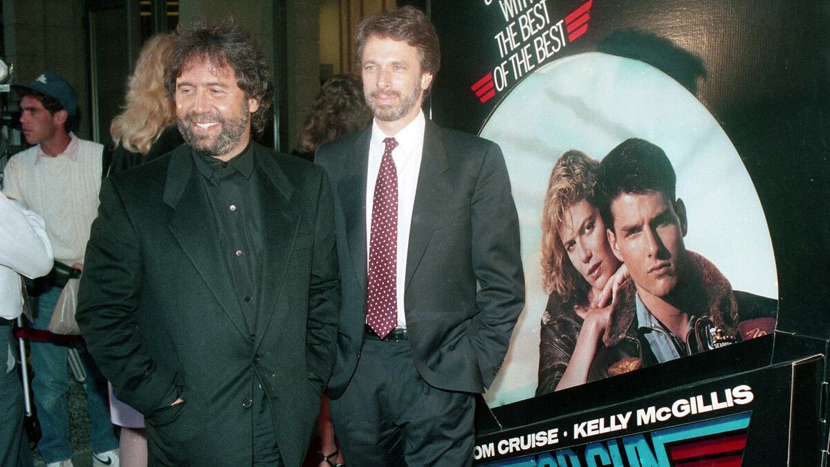 Producers Don Simpson and Jerry Bruckheimer stand in front of the movie poster at the benefit West Coast premiere of the film "Top Gun" at Mann's Cinema 21 in Mission Valley on May 15, 1986. (Photo by Bob Redding/The San Diego Union-Tribune) User Upload Caption: U-T file photos at the West Coast premiere of the movie "Top Gun" at Mann's Cinema 21 in Mission Valley on May 15, 1986.