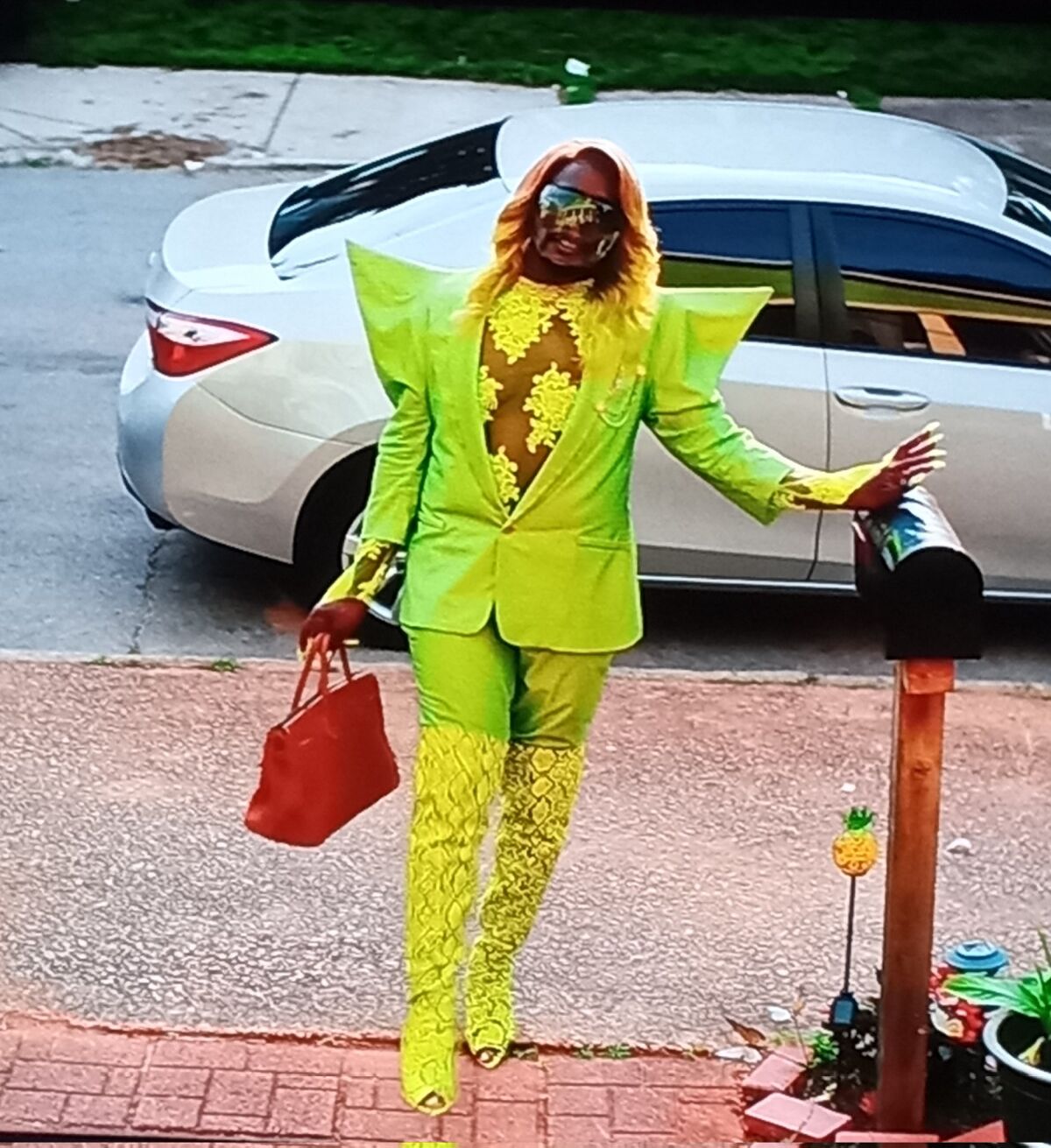A person wearing a lime green suit walks.