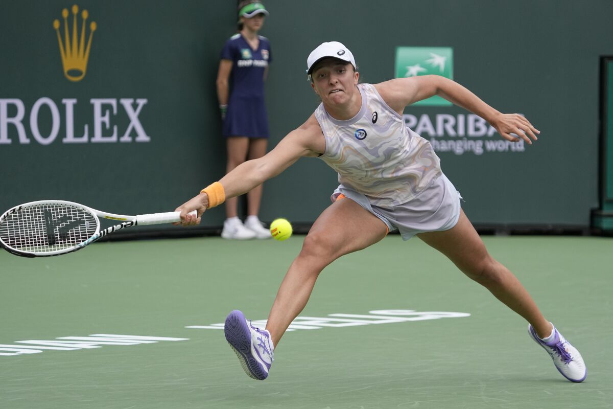 Iga Swiatek stretches to hit a return during her victory over Claire Liu in the BNP Paribas Open.