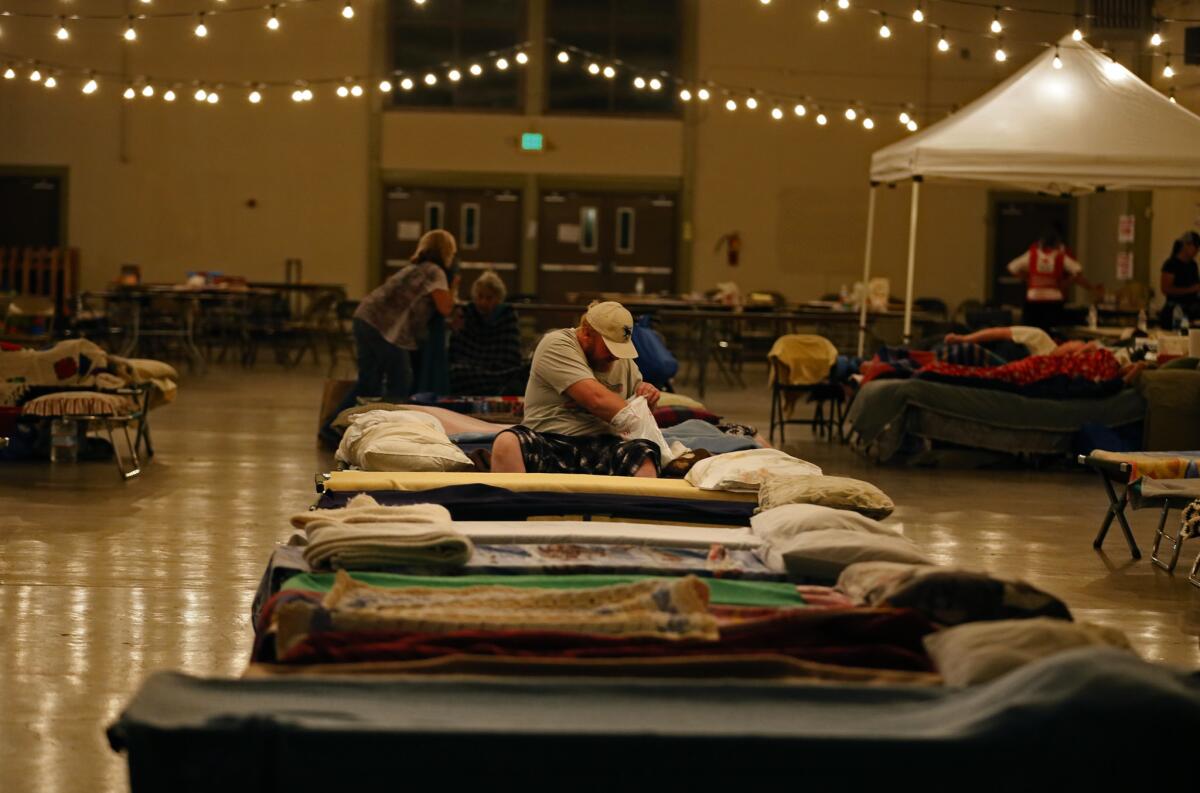 Dave Burns digs into a Red Cross toiletries bag before bedding down on a cot at the Napa County Fairgrounds evacuation center in Calistoga. The 50-year resident of Middletown said the Valley fire rolled over his family's truck and heavy equipment business.