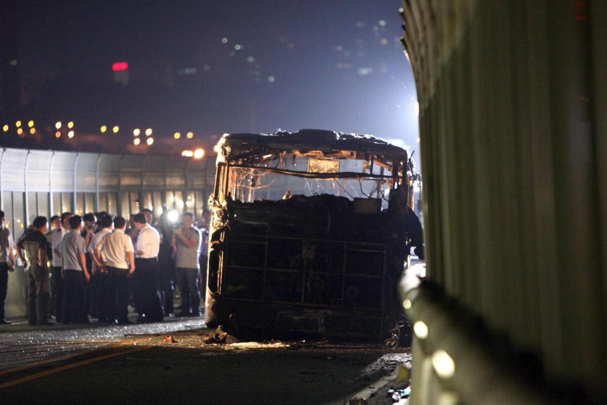 Investigators at the scene of a bus fire Friday in Xiamen, China, that killed 47 people, including the disgruntled man authorities said set the blaze.