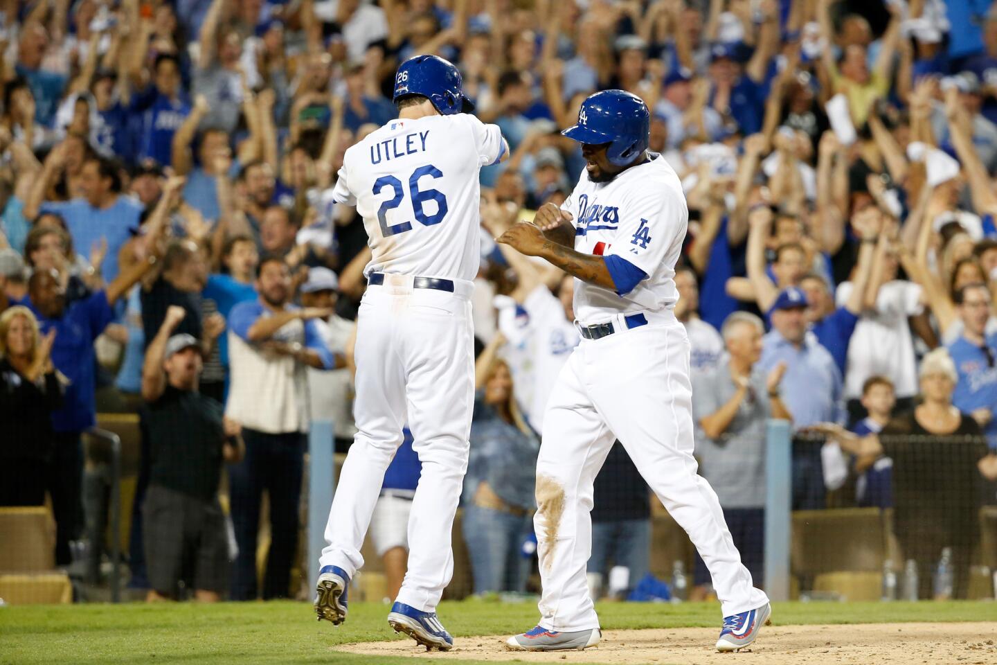 Chase Utley #26 and Howie Kendrick #47 of the Los Angeles Dodgers celebrate after scoring on a two-RBI double by Adrian Gonzalez #23 in the seventh inning against the New York Mets in game two of the National League Division Series at Dodger Stadium.