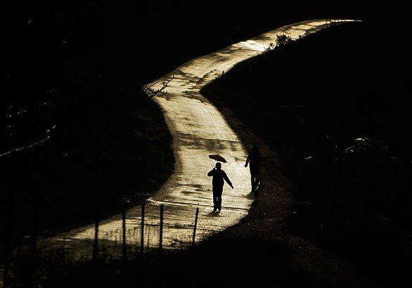 A Palestinian braces against the rain as he walks along a deserted road during a rainy day in the West Bank city of Ramallah. Events were held throughout the territories this week to mark Jerusalem's designation as the 2009 "capital of Arab culture" though Israel banned any functions in the city itself.