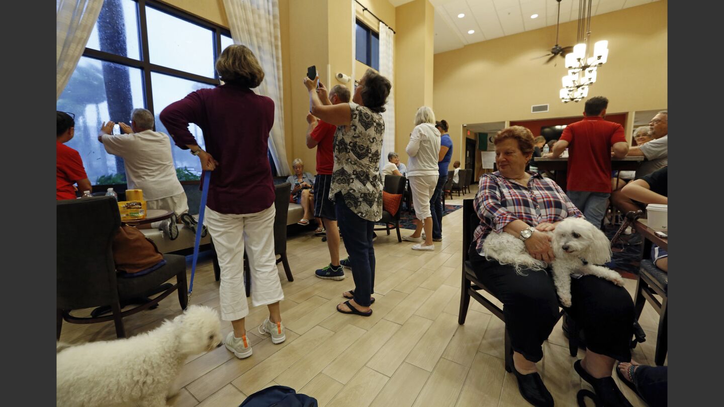 Guests gather in the lobby of Hampton Inn and Suites in Estero, Fla., to watch the hurricane gusts.