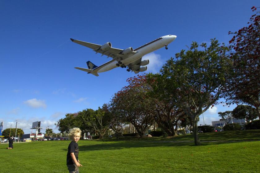 LOS ANGELES, CA - APRIL 1, 2013: Noah Moss,3, of Maui plays on the grass knoll as a plane prepares to land at the north runway at Los Angeles International Airport near Sepulveda Boulevard and 92 Street on April 1, 2013 in Los Angeles, California. Mayoral candidate Eric Garcetti now says he will vote against a $750 million expansion proposal to push the north runway 260 feet closer to Westchester and Playa Del Rey. His decision comes just days after Garcetti received the endorsement of the Alliance for a Regional Solution to Airport Congestion, an advocacy group that has been fighting the runway expansion plan.(Gina Ferazzi / Los Angeles Times)