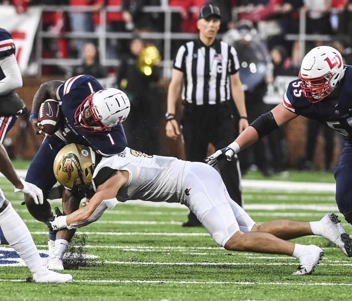Liberty's Kaidon Salter, left, is tackled by UAB's Jackson Bratton during an NCAA college football game Saturday, Sept. 10, 2022, in Lynchburg, Va. (Paige Dingler/The News & Advance via AP)