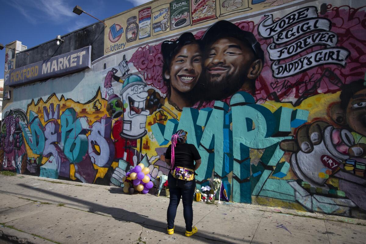 Justine Mendiola looks at a mural honoring Kobe and Gianna Bryant outside Pickford Market.