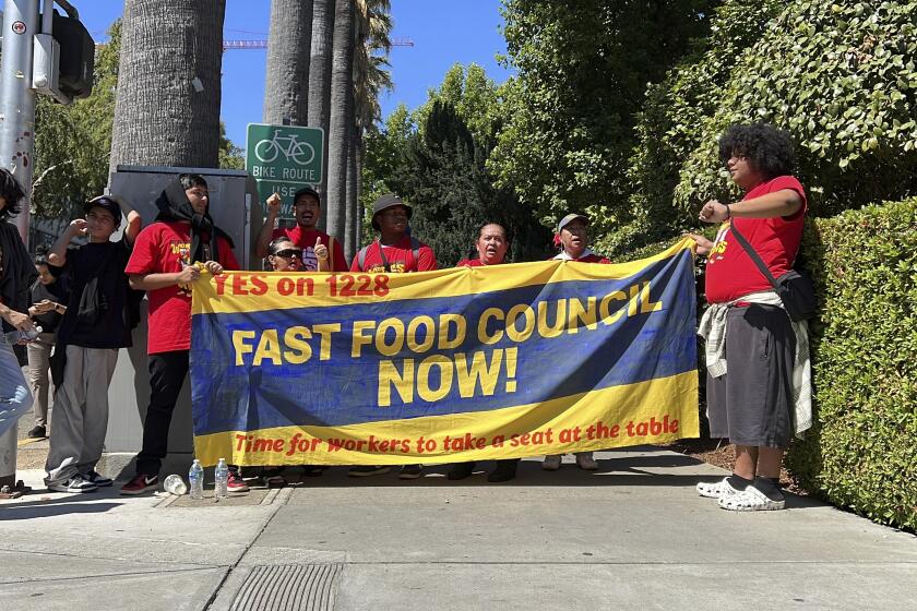 FILE -- Fast food workers and union activists demonstrate outside the California State Capitol to rally support for legislation to increase fast-food worker wages on Friday, Sept. 15, 2023, in Sacramento, Calif. On Thursday, Sept. 28, 2023, Democratic Gov. Gavin Newsom signed a law giving fast food workers a $20 minimum wage on April 1, 2024. (AP Photo/Terry Chea, File)