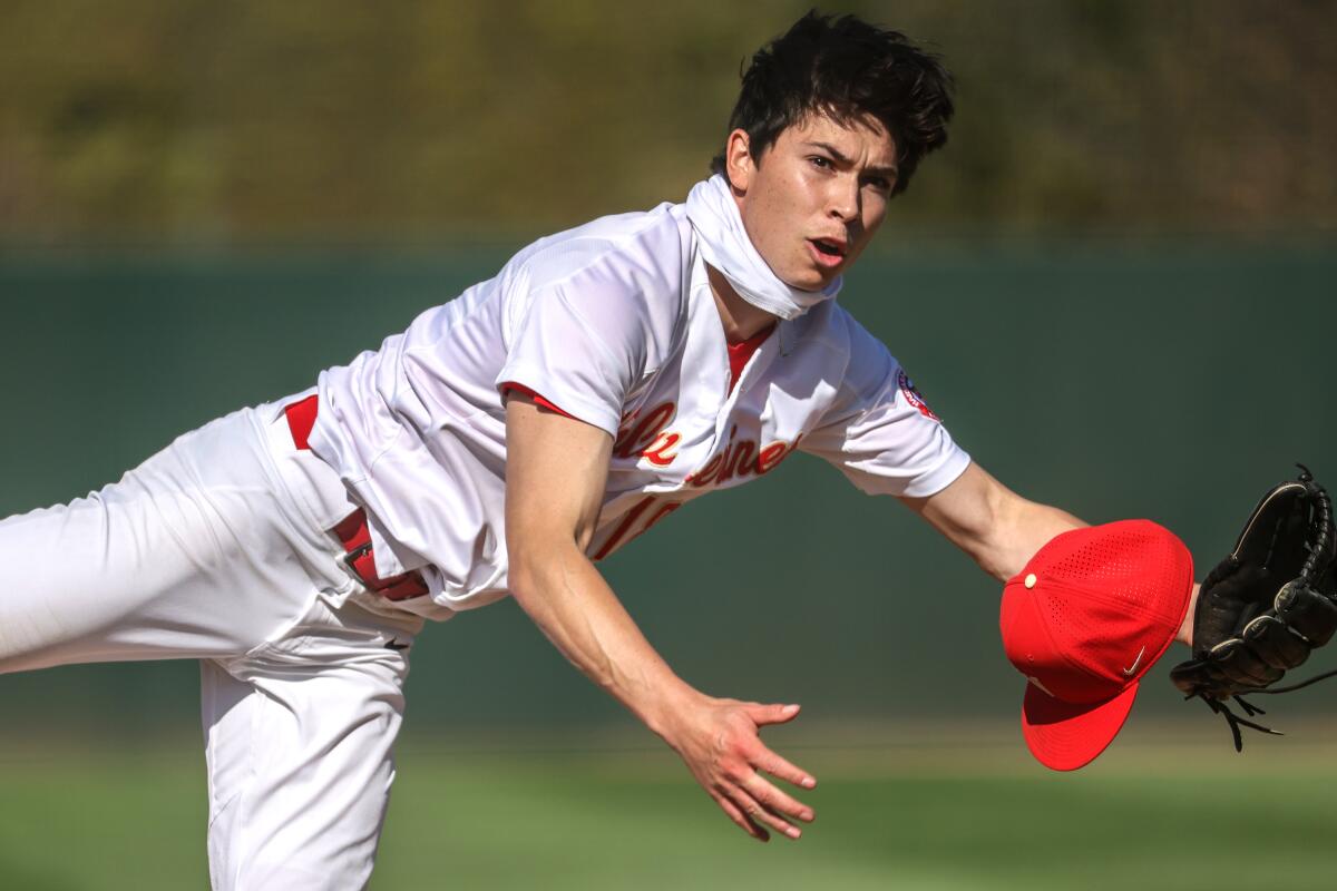 Harvard-Westlake pitcher Christian Becerra loses his cap during a windy day in Encino.