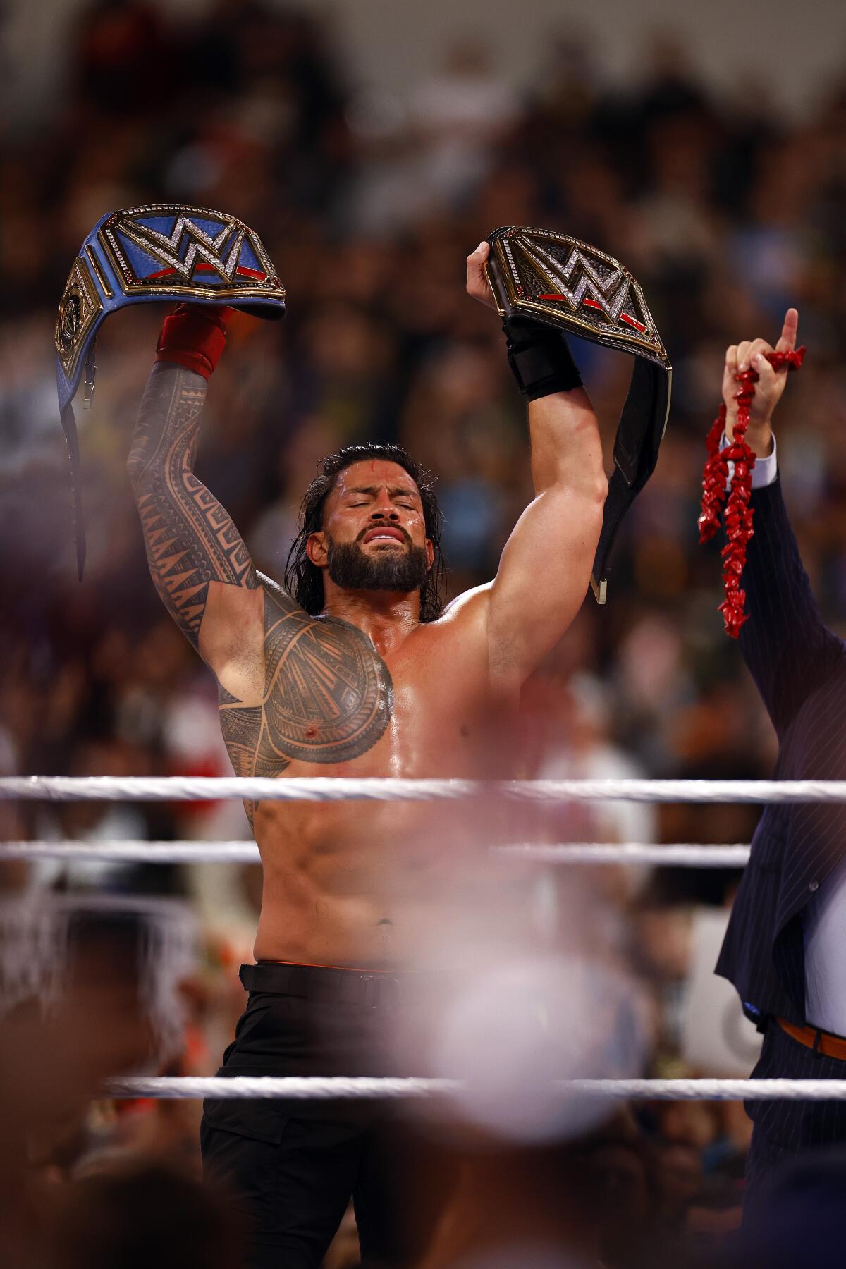 Roman Reigns celebrates after defeating Cody Rhodes to retain the undisputed universal title at WrestleMania 39.