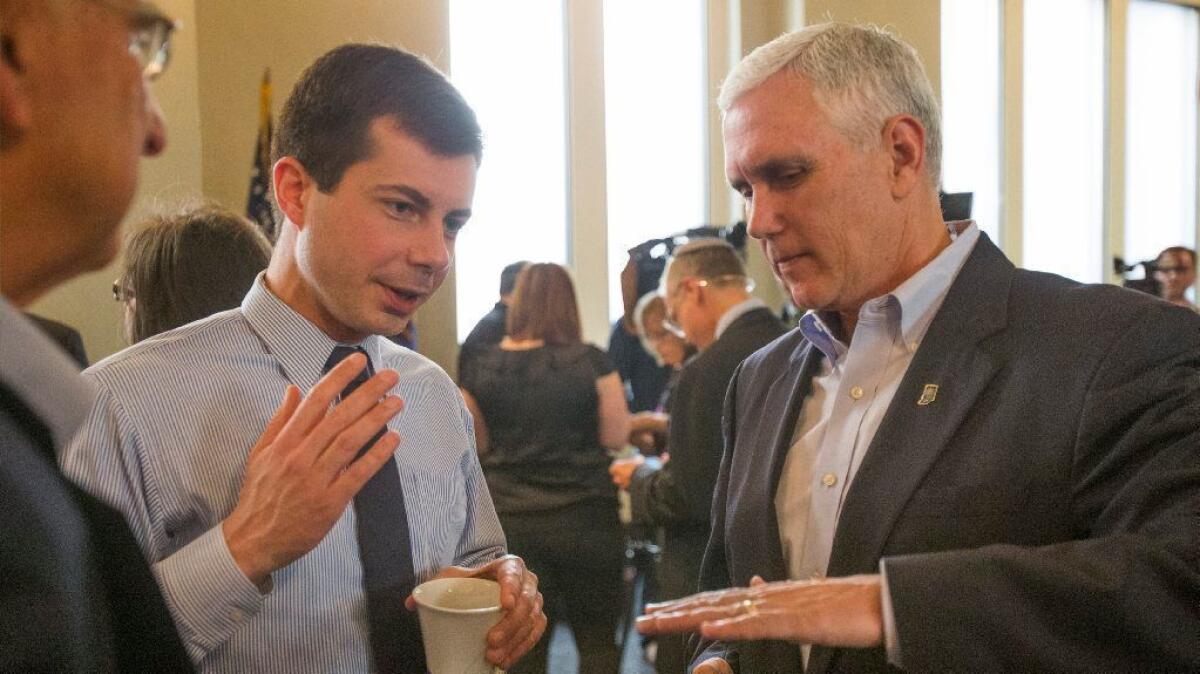 South Bend, Ind., Mayor Pete Buttigieg, left, speaks with then-Indiana Gov. Mike Pence on May 1, 2015.