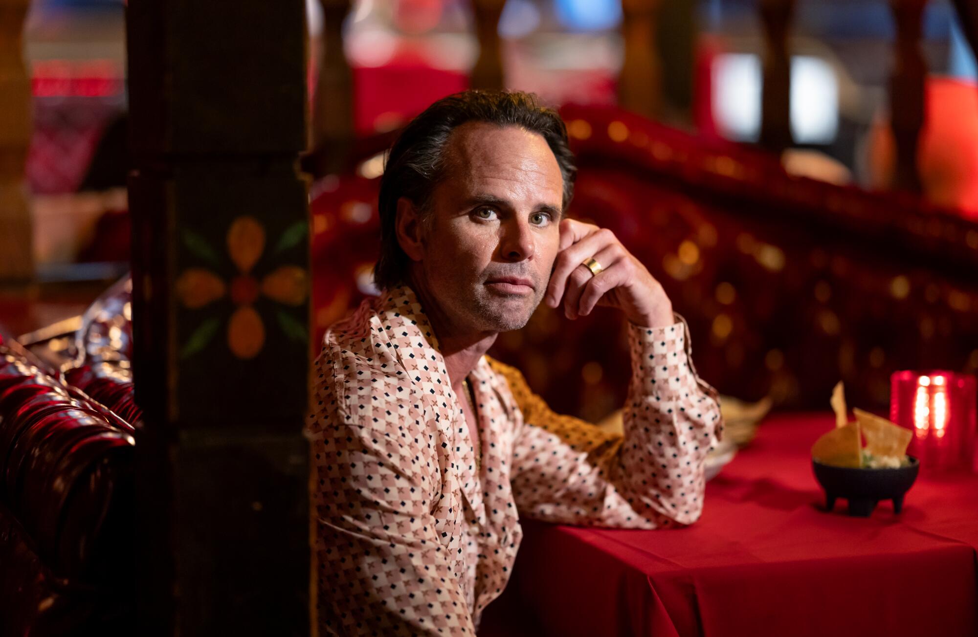 Walton Goggins sitting and leaning his arm on a table.