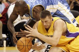 FILE - Los Angeles Lakers' Slava Medvedenko, right, of Ukraine, and Denver Nuggets' Francisco Elson, top, of the Netherlands, dive for the ball in the first quarter of a preseason NBA basketball game in Los Angeles, Oct. 20, 2005. Former Lakers player Medvedenko is selling his two NBA championship rings to raise money for his native Ukraine. (AP Photo/ Francis Specker, File)