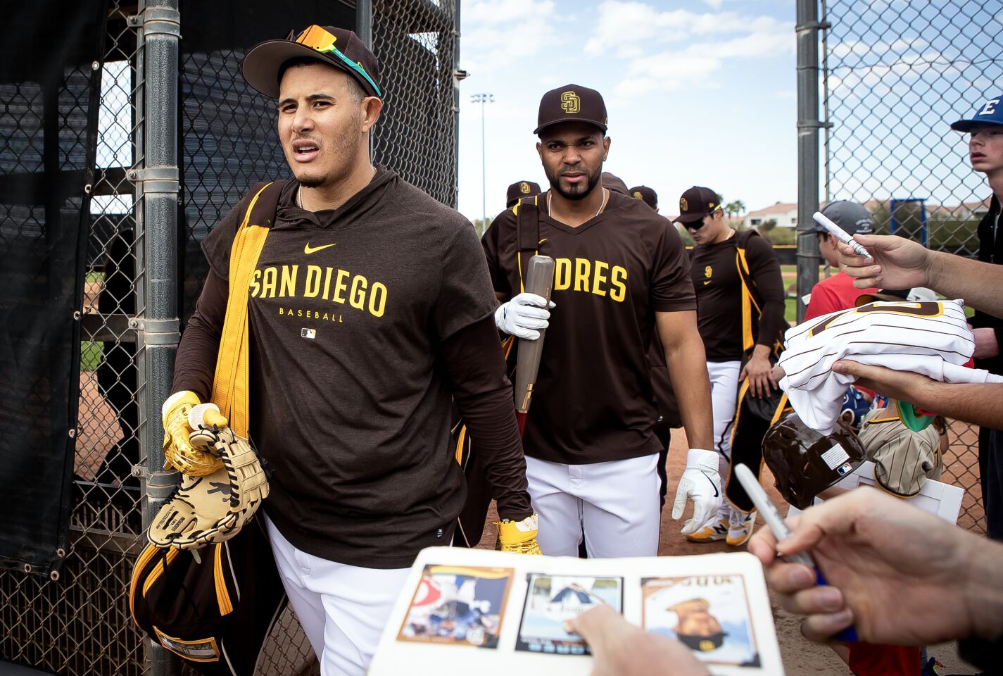 Padres third baseman Manny Machado (13) and shortstop Xander Bogaerts (2) and shortstop Ha-Seong Kim (7) exit the field as fans beg for autographs during a spring training practice at the Peoria Sports Complex on Tuesday, Feb. 21, 2023 in Peoria, AZ.