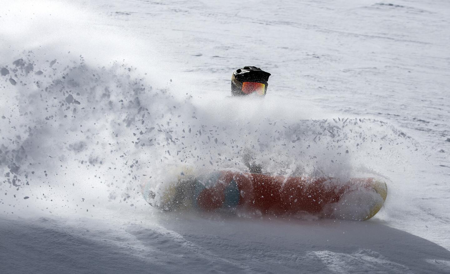 A snowboarder plows through the Cornice Bowl at Mammoth Mountain.