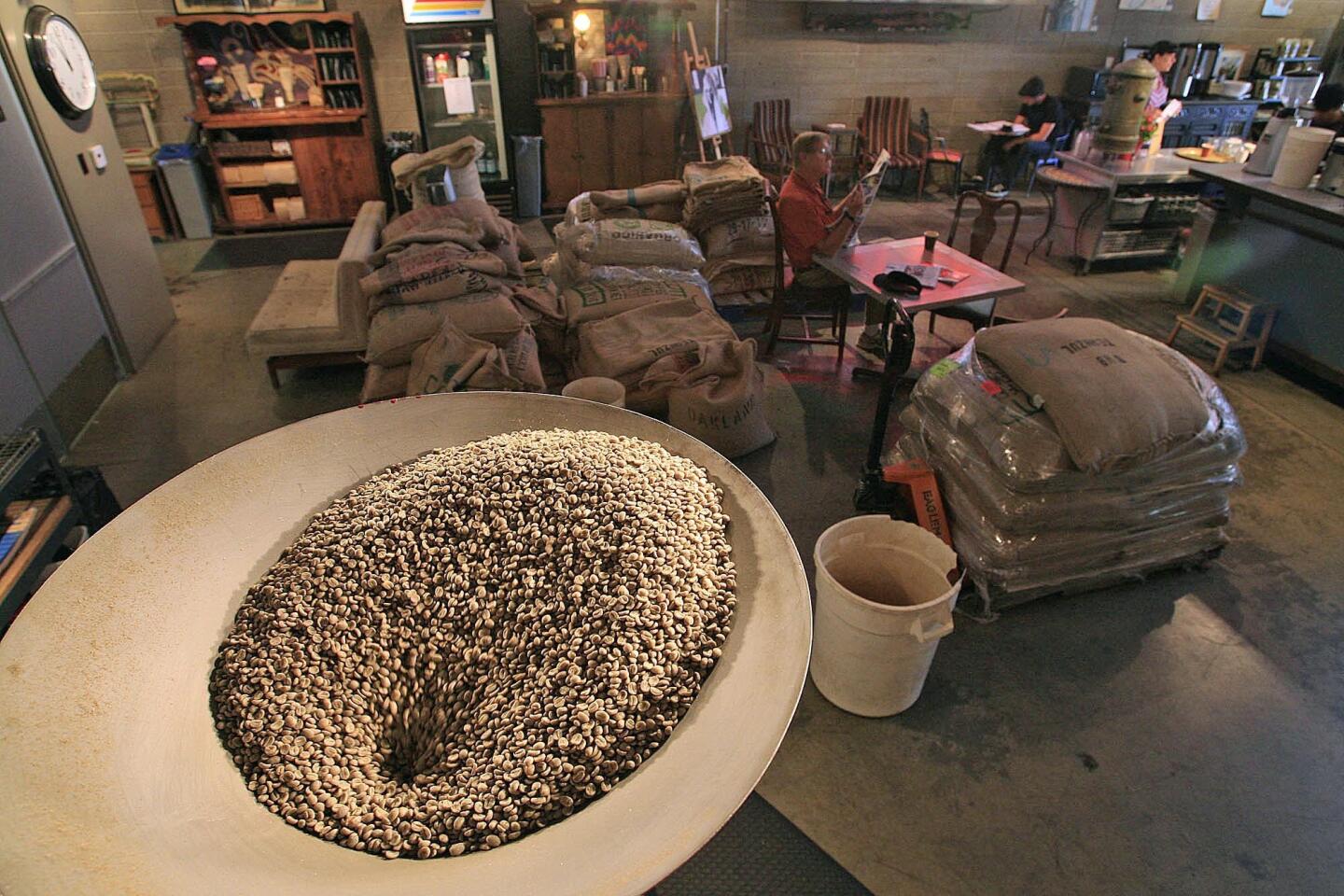 Pre-roasted coffee beans are put into the drum of a roaster at Jones Coffee Roasters in Pasadena.