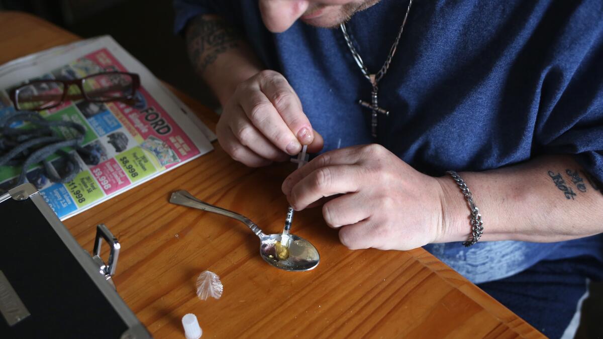 A heroin user prepares to shoot up in New London, Conn., an area hit hard by the surging heroin problem.