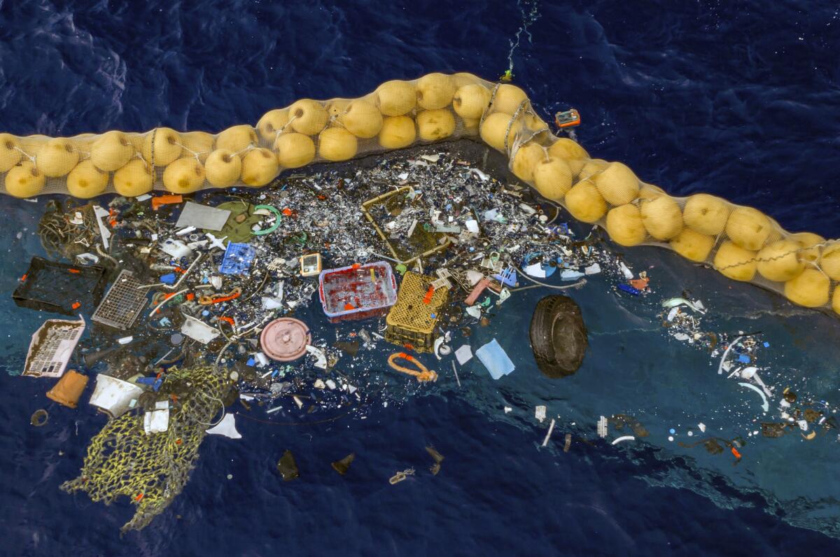 Plastic is retained in front of an extended cork line in the Pacific Ocean.  