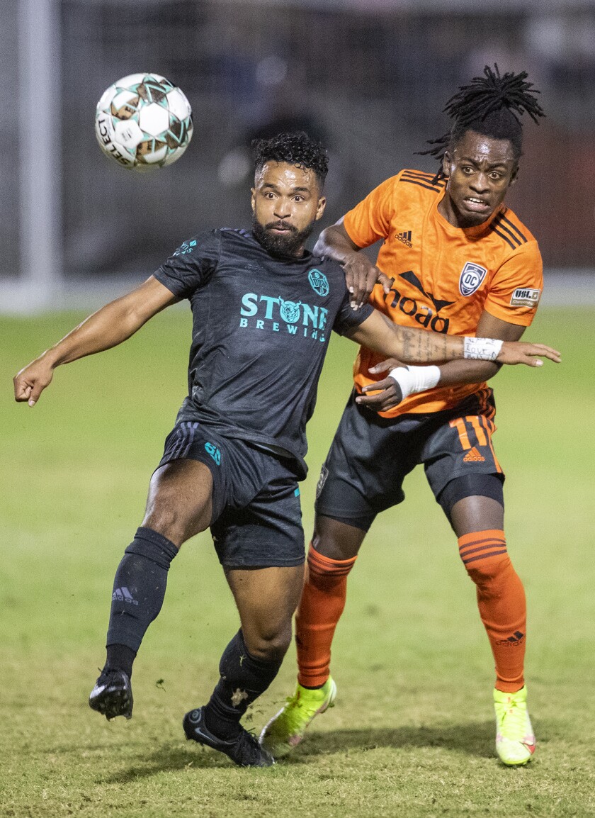 Orange County Soccer Club's Ronaldo Damus battles for control of a ball with San Diego Loyal's Elijah Martin.