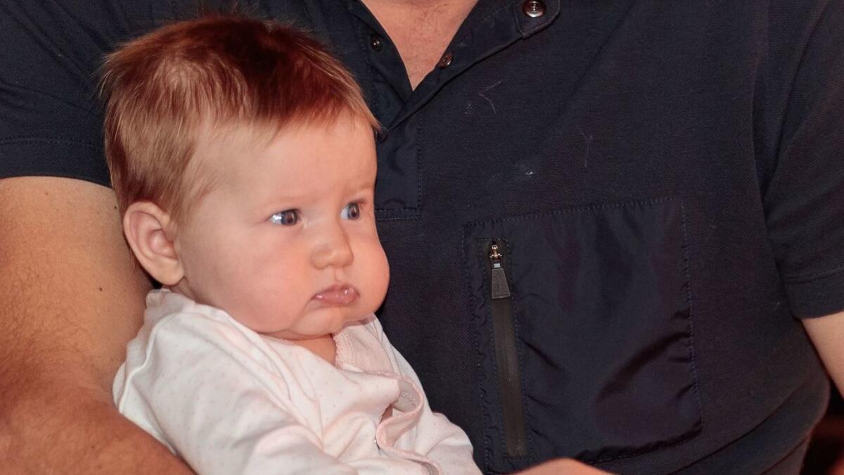 Emeline Miller in a 2017 file photo, being held by her father.