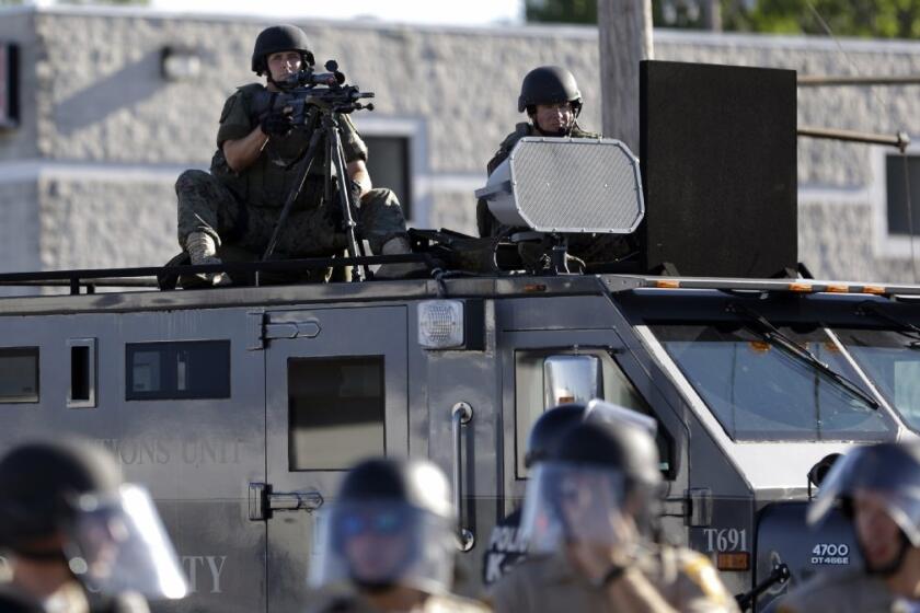 A police tactical team moves in to disperse a group of protesters in Ferguson, Mo., on Aug. 9.