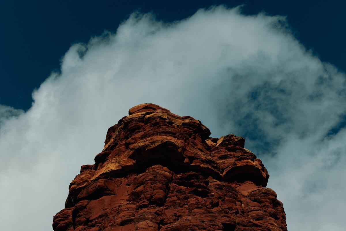 A view of a rock formation looks up to the clouds.